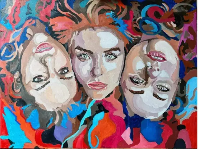 An oil painting of three women lying in a circle with their heads touching, forming a mandala, painted in saturated psychedelic blues, crimson, orange and turquoise, their pale faces built from blocks of colour and their hair merging into the background.